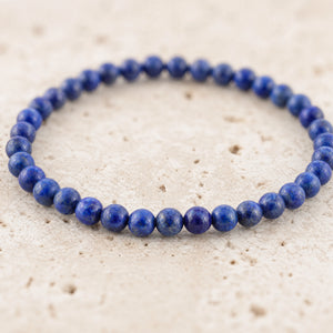 Close-up of the Lapis Lazuli 4mm Round Bead Bracelet on pale travertine
