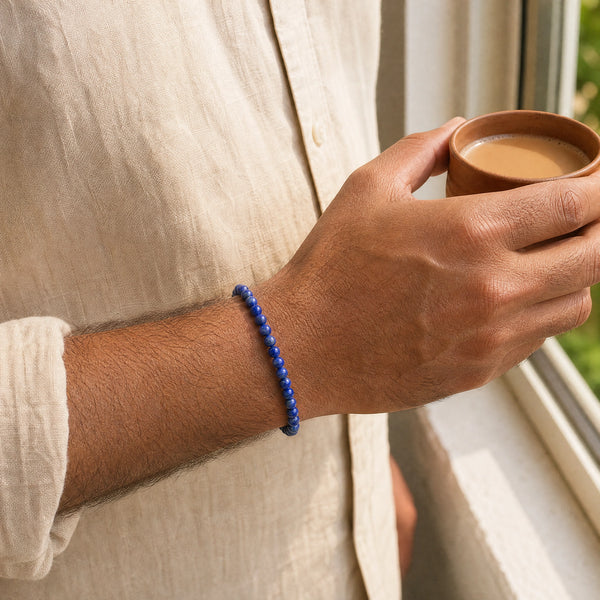 Man wearing the Lapis Lazuli bracelet, holding a cup of chai