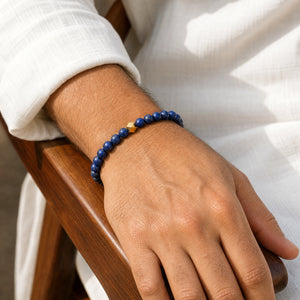 Man wearing the Lapis Lazuli 6mm Bead Bracelet with Gold Accent with a white kurta