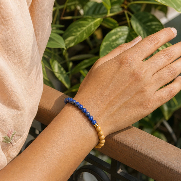 Woman wearing the Lapis Lazuli & Rosewood 6mm Bead Bracelet with a peach cotton top