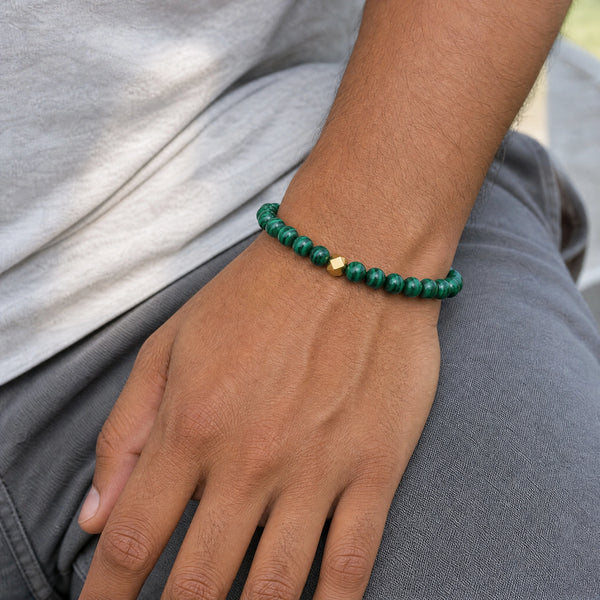 Man wearing the Malachite 6mm Bead Bracelet with Gold Accent with a grey t-shirt