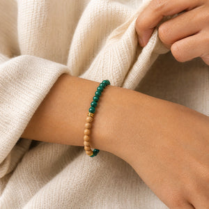 Woman wearing the Malachite & Rosewood 6mm Bead Bracelet with a cream knit cardigan
