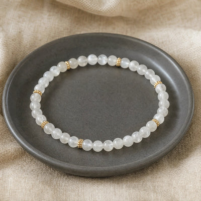Soultheory Moonstone 4mm Bead Bracelet with Gold Spacers on a charcoal ceramic dish on linen