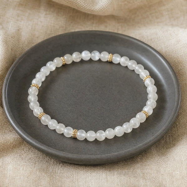 Soultheory Moonstone 4mm Bead Bracelet with Gold Spacers on a charcoal ceramic dish on linen
