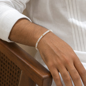 Man wearing the Moonstone 4mm Bead Bracelet with Gold Spacers with a white kurta