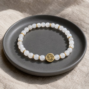Soultheory Moonstone 4mm Bracelet with Om Charm on a charcoal ceramic dish on linen