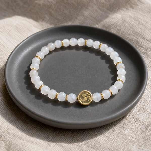 Soultheory Moonstone 4mm Bracelet with Om Charm on a charcoal ceramic dish on linen