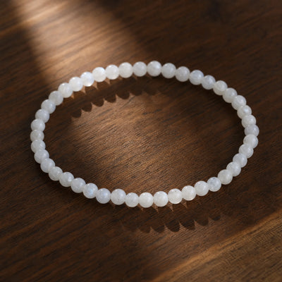 Soultheory Moonstone 4mm Round Bead Bracelet on dark walnut wood