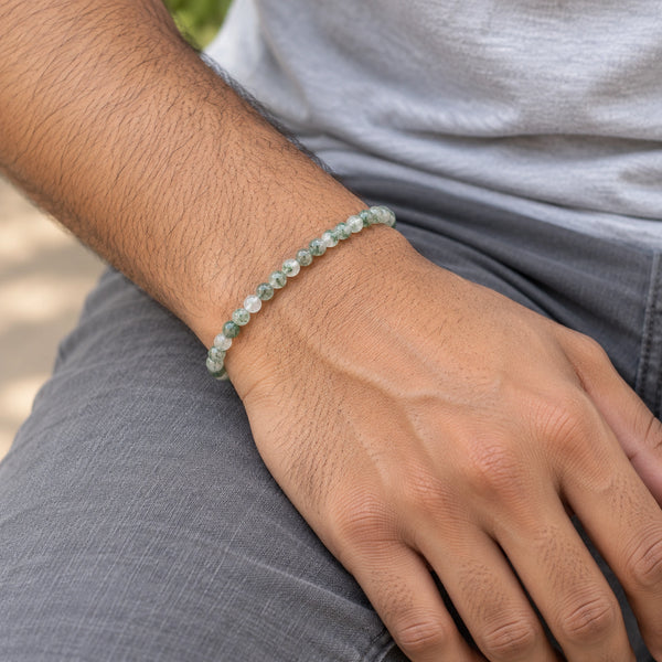 Man wearing the Moss Agate 4mm Round Bead Bracelet with a grey t-shirt