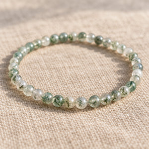 Close-up of the Moss Agate 4mm Round Bead Bracelet on natural linen
