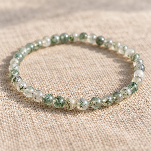 Close-up of the Moss Agate 4mm Round Bead Bracelet on natural linen