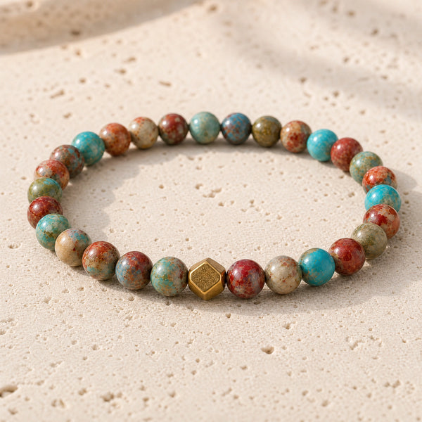 Close-up of the Multi Imperial Jasper 6mm Bead Bracelet with Gold Accent on pale travertine