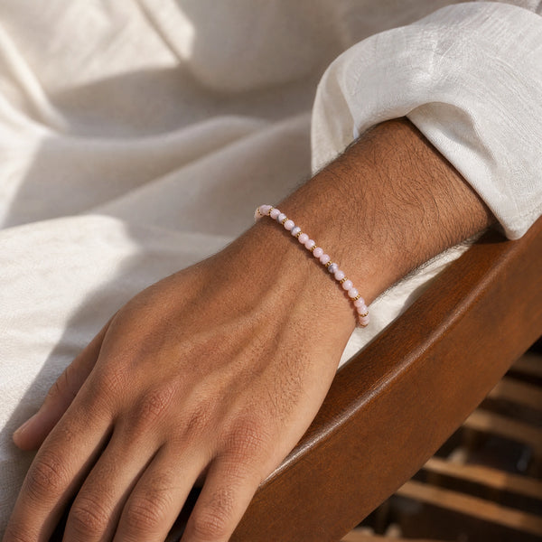 Man wearing the Pink Opal 4mm Bead Bracelet with Gold Spacers with a white kurta