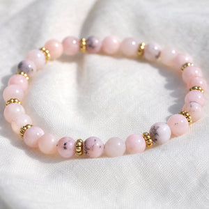 Close-up of the Pink Opal 4mm Bead Bracelet with Gold Spacers on white linen