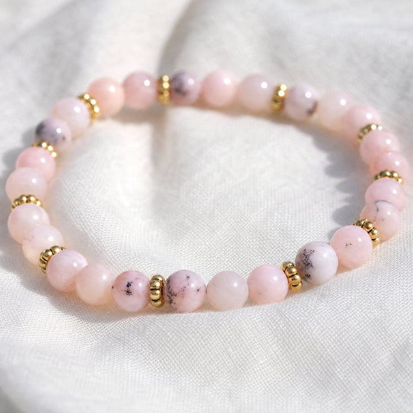 Close-up of the Pink Opal 4mm Bead Bracelet with Gold Spacers on white linen