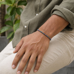 Man wearing the Rainbow Hematite 4mm Bead Bracelet with an olive linen shirt