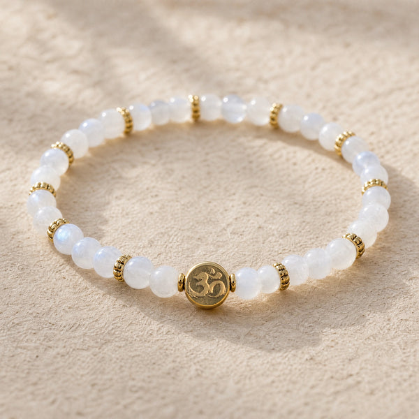Close-up of the Rainbow Moonstone 4mm Bracelet with Om Charm on cream handmade paper