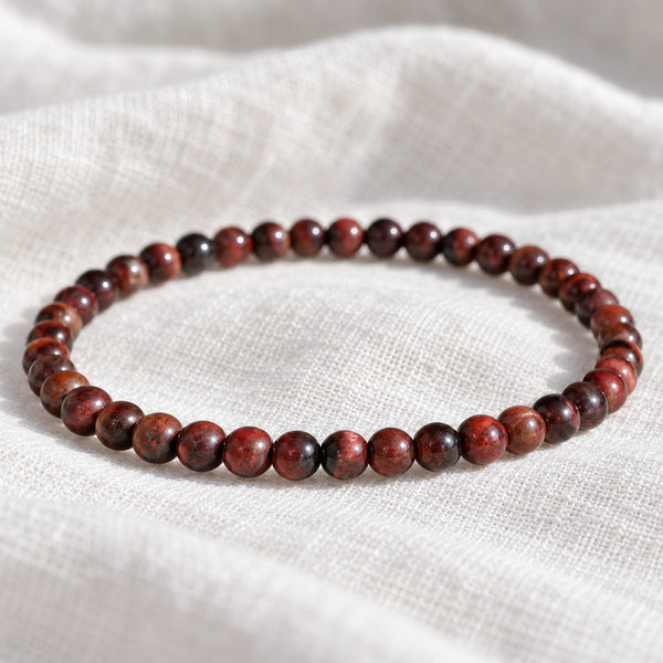Close-up of the Red Tiger Eye 4mm Round Bead Bracelet on white linen