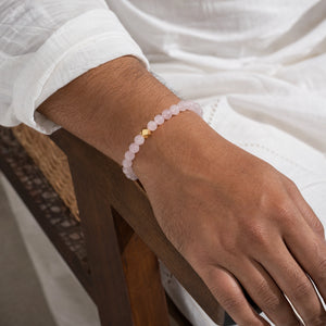 Man wearing the Rose Quartz 6mm Bead Bracelet with Gold Accent with a white kurta