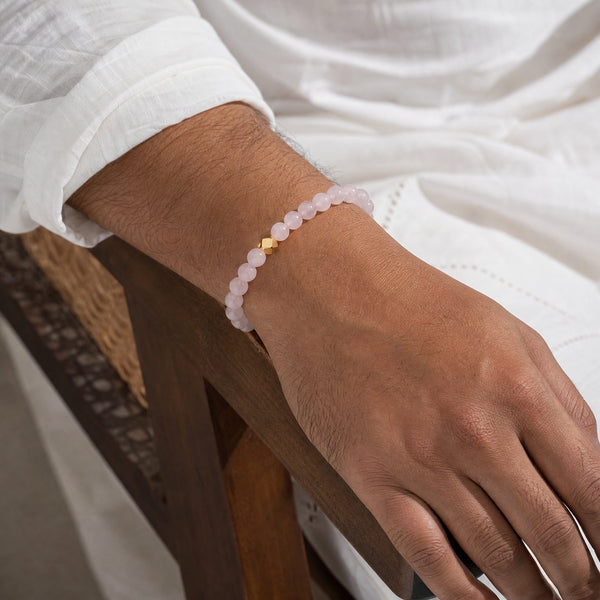 Man wearing the Rose Quartz 6mm Bead Bracelet with Gold Accent with a white kurta