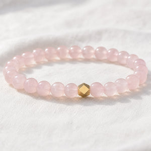 Close-up of the Rose Quartz 6mm Bead Bracelet with Gold Accent on white linen