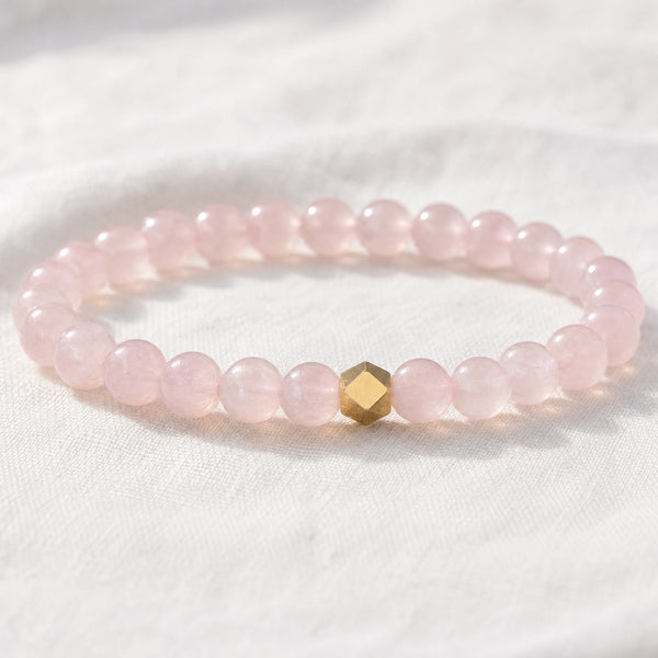 Close-up of the Rose Quartz 6mm Bead Bracelet with Gold Accent on white linen