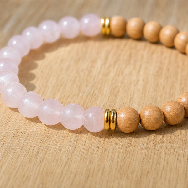 Close-up of the Rose Quartz & Rosewood 6mm Bead Bracelet on a light oak board