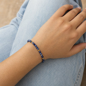 Woman wearing the Sodalite 4mm Bead Bracelet with Gold Spacers with blue denim