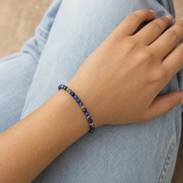 Woman wearing the Sodalite 4mm Bead Bracelet with Gold Spacers with blue denim