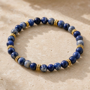 Close-up of the Sodalite 4mm Bead Bracelet with Gold Spacers on a pale stone surface