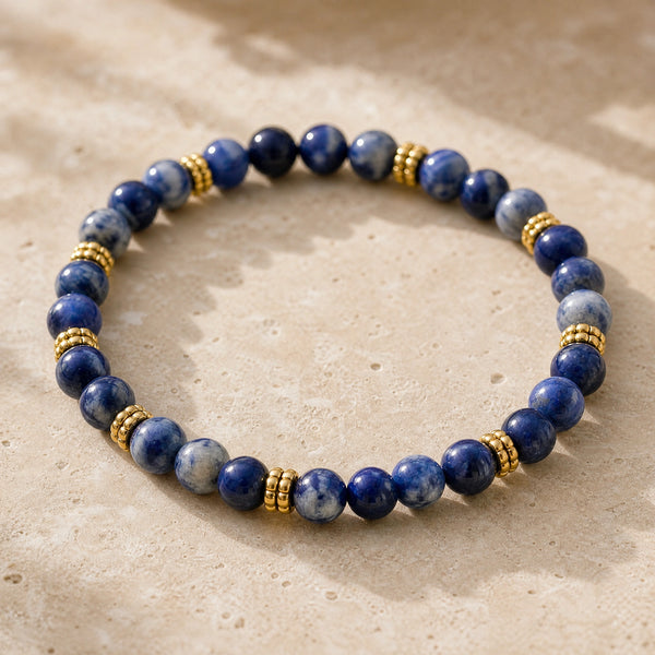 Close-up of the Sodalite 4mm Bead Bracelet with Gold Spacers on a pale stone surface