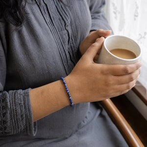 Woman wearing the Sodalite bracelet, holding a mug of tea