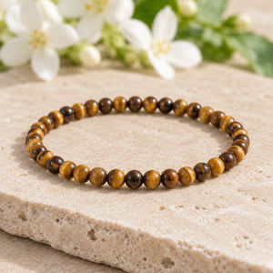 Soultheory Tiger Eye 4mm Round Bead Bracelet on a limestone plinth with jasmine