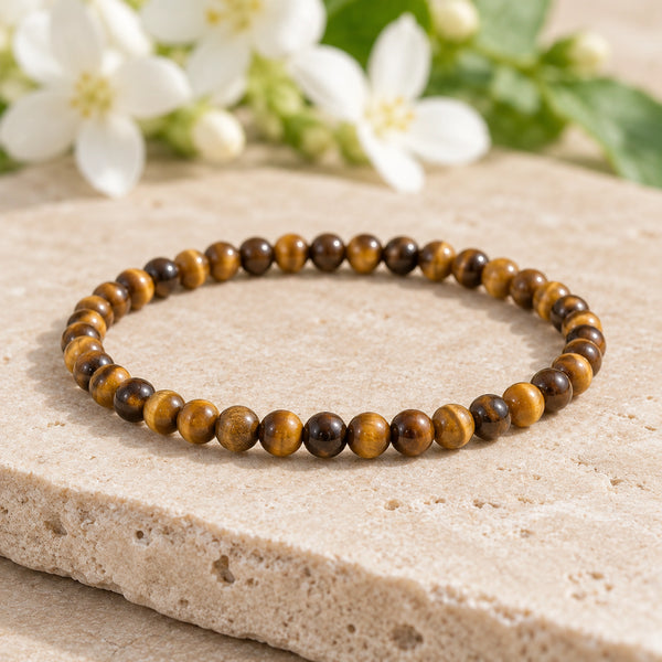 Soultheory Tiger Eye 4mm Round Bead Bracelet on a limestone plinth with jasmine