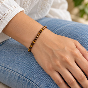 Woman wearing the Tiger Eye 4mm Round Bead Bracelet with blue denim