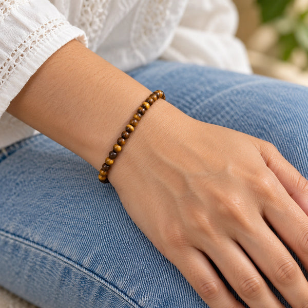Woman wearing the Tiger Eye 4mm Round Bead Bracelet with blue denim