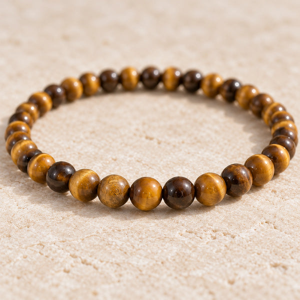 Close-up of the Tiger Eye 4mm Round Bead Bracelet on cream handmade paper