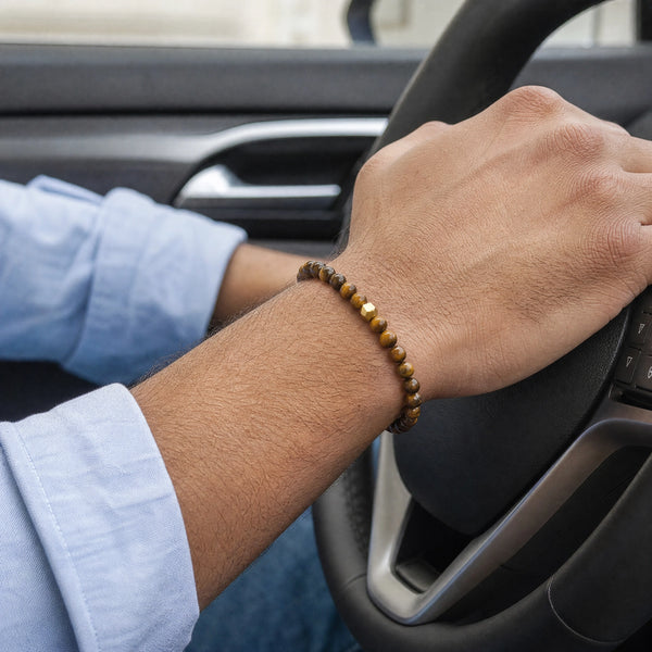 Man wearing the Tiger Eye bracelet, while driving