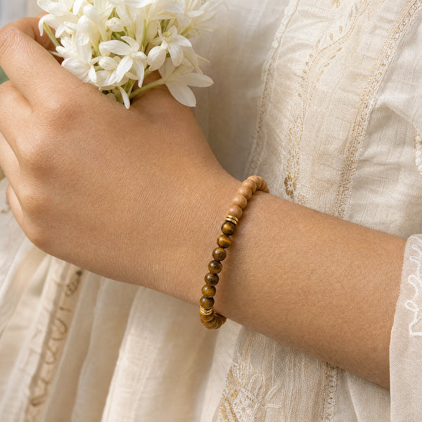 Woman wearing the Tiger Eye bracelet, holding fresh jasmine flowers