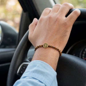 Man wearing the Tiger Eye Om charm bracelet while driving