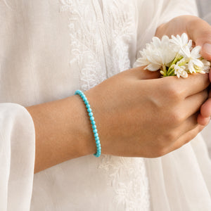 Woman wearing the Turquoise bracelet, holding fresh jasmine flowers