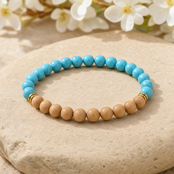 Soultheory Turquoise & Rosewood 6mm Bead Bracelet on a sandstone block with white flowers