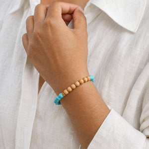 Woman wearing the Turquoise & Rosewood 6mm Bead Bracelet with a white linen shirt