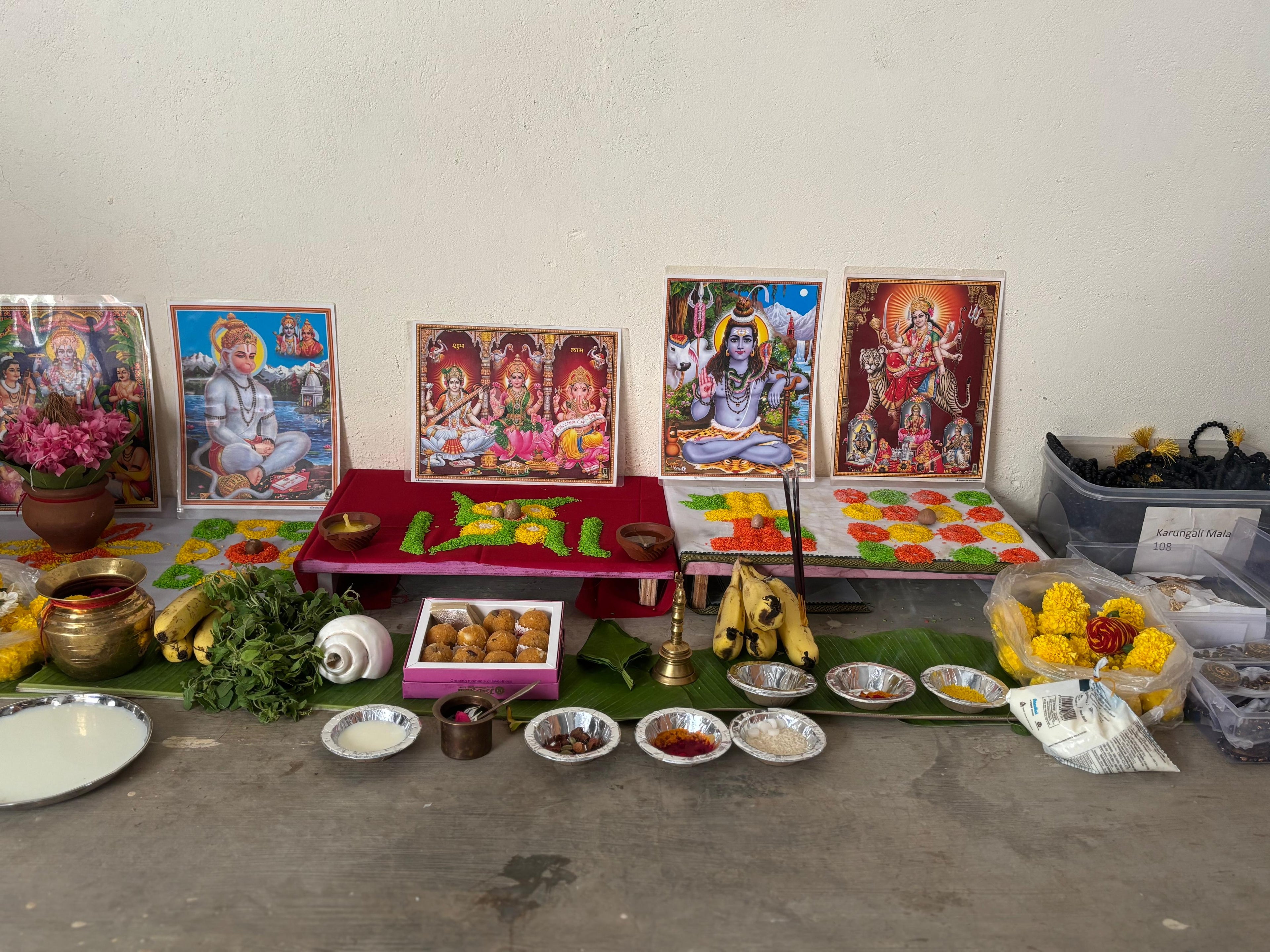 Prajapati Agarwal's puja altar with various items including fruits, flowers, and pictures of deities.