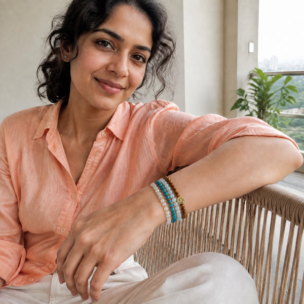 Abundance option A1: natural face-visible portrait wearing the four dainty 4 mm crystal bracelets with Soultheory's gold charm