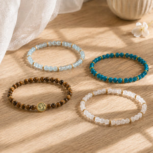 Tiger's Eye, Aquamarine, Apatite and Moonstone bracelets individually arranged on a sunlit oak table with Soultheory's photographed charm