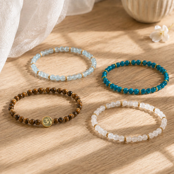 Tiger's Eye, Aquamarine, Apatite and Moonstone bracelets individually arranged on a sunlit oak table with Soultheory's photographed charm
