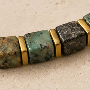 Close-up of African turquoise cube beads showing green and black matrix with gold spacers