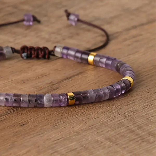 Close-up of amethyst heishi beads with gold spacers and a macrame knot on the adjustable bracelet