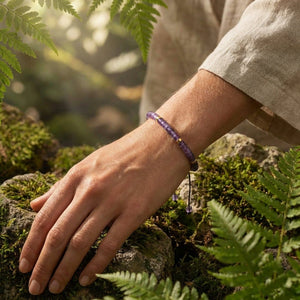 Amethyst 4mm bracelet worn on a wrist outdoors among ferns, adjustable cord for calm and spiritual growth
